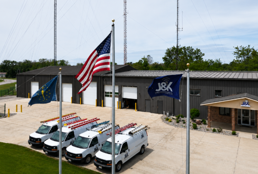 J&K Communications facility in Columbia City, Indiana, with service vehicles and flags